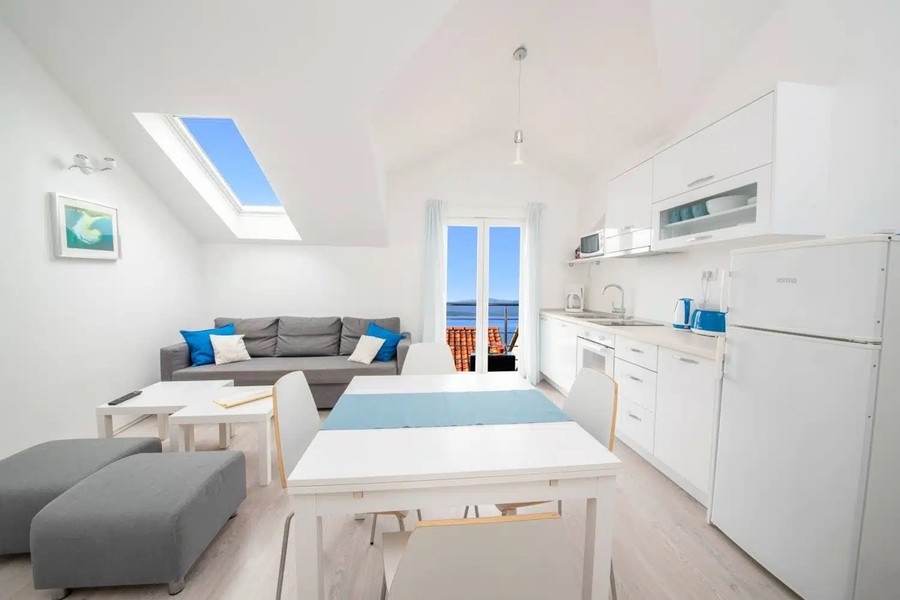 Offener Wohnraum mit Küche und Blick zum Balkon