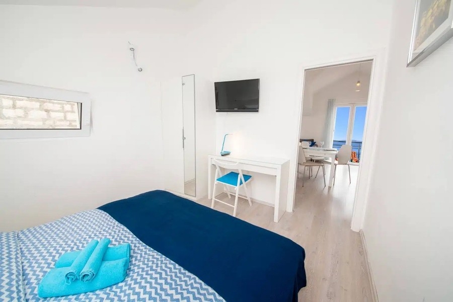 Schlafzimmer mit Doppelbett und Fernseher