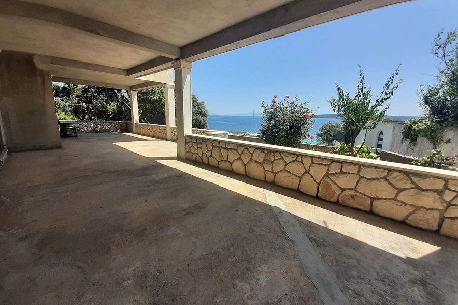 Große Terrasse mit Natursteinmauer und Meerblick