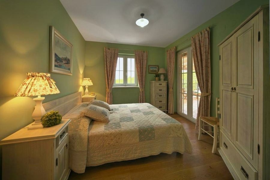 Schlafzimmer mit Doppelbett und grünen Wänden