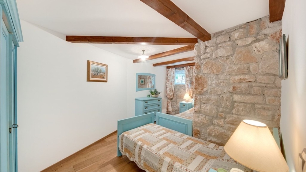 Einzelzimmer mit Steinwand und Holzbalken