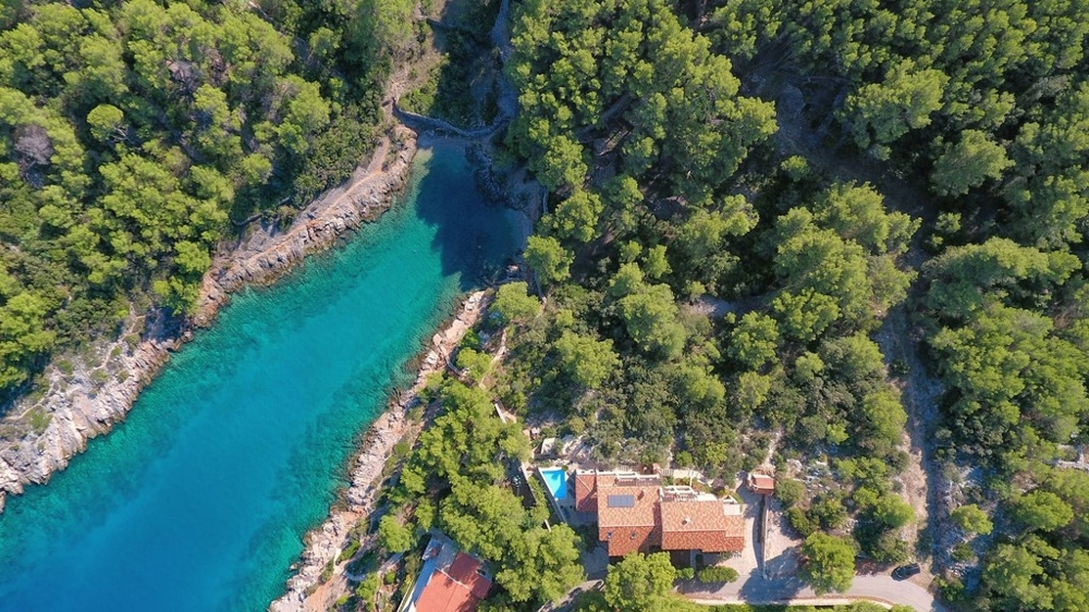 Luftaufnahme der Bucht mit dem Haus im Pinienwald