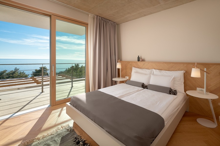 Schlafzimmer mit großer Fensterfront und Meerblick