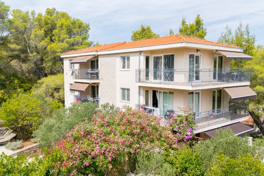 Außenansicht der Villa mit Balkonen und Garten