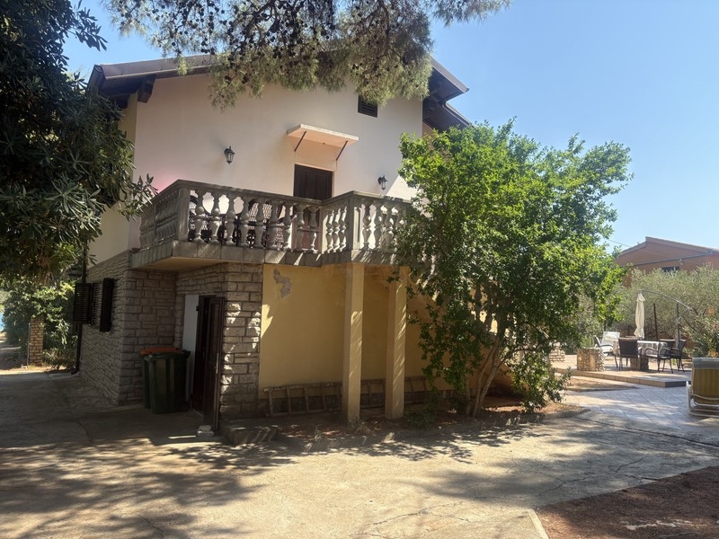 Hausansicht mit Balkon und Steinfassade im Erdgeschoss