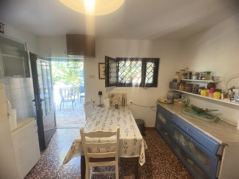 Küche mit Esstisch und Tür zur Terrasse