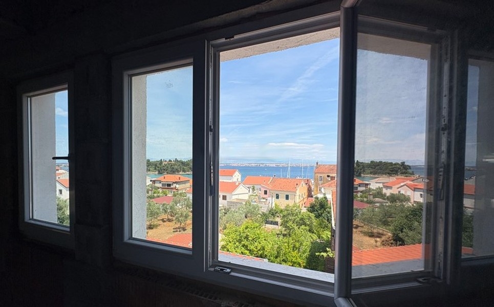 Blick aus dem Fenster auf Meer und Hafen
