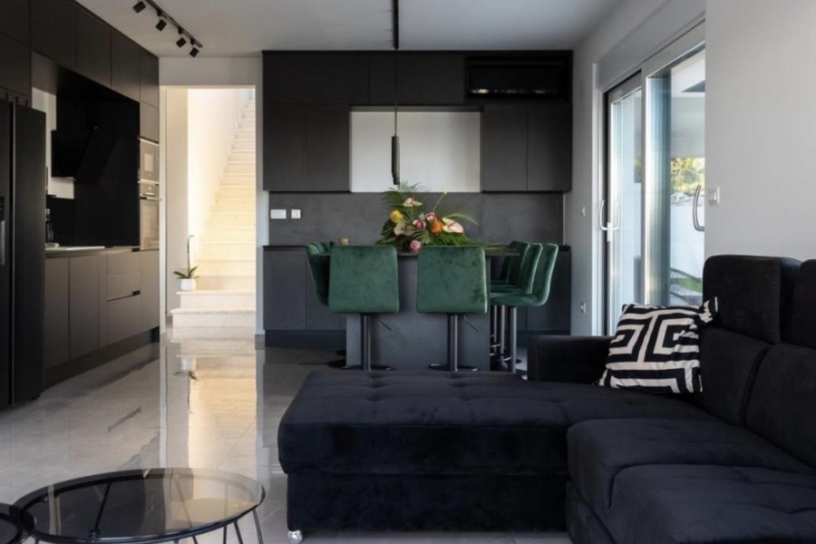 Wohnzimmer mit Ecksofa und offener Küche