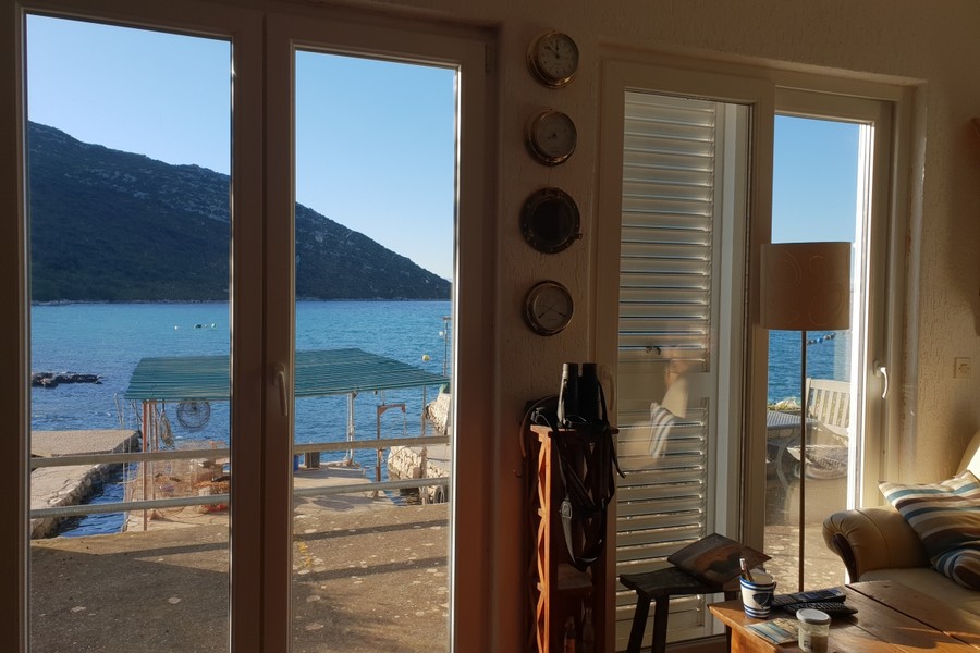 Blick durch die Terrassentür auf das Meer