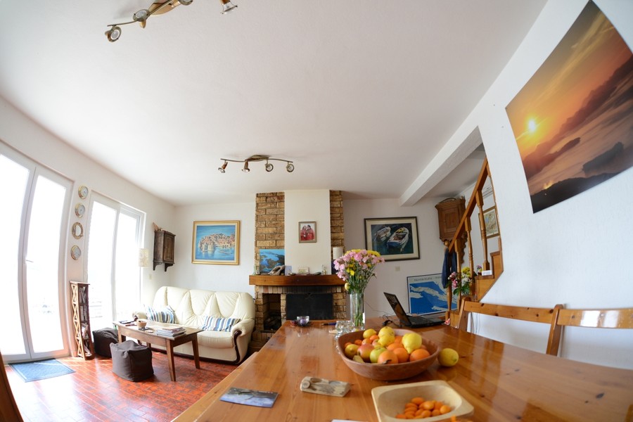 Wohnzimmer mit Esstisch und Kamin