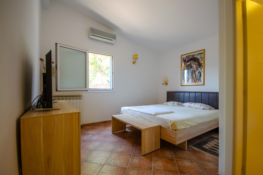 Schlafzimmer mit Doppelbett und Fernseher