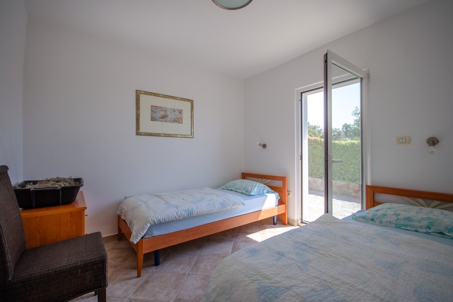 Schlafzimmer mit Einzelbett und Zugang nach draußen