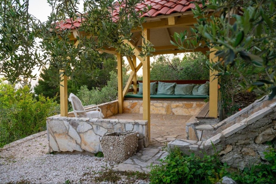 Pergola mit Sitzbank zwischen Olivenbäumen