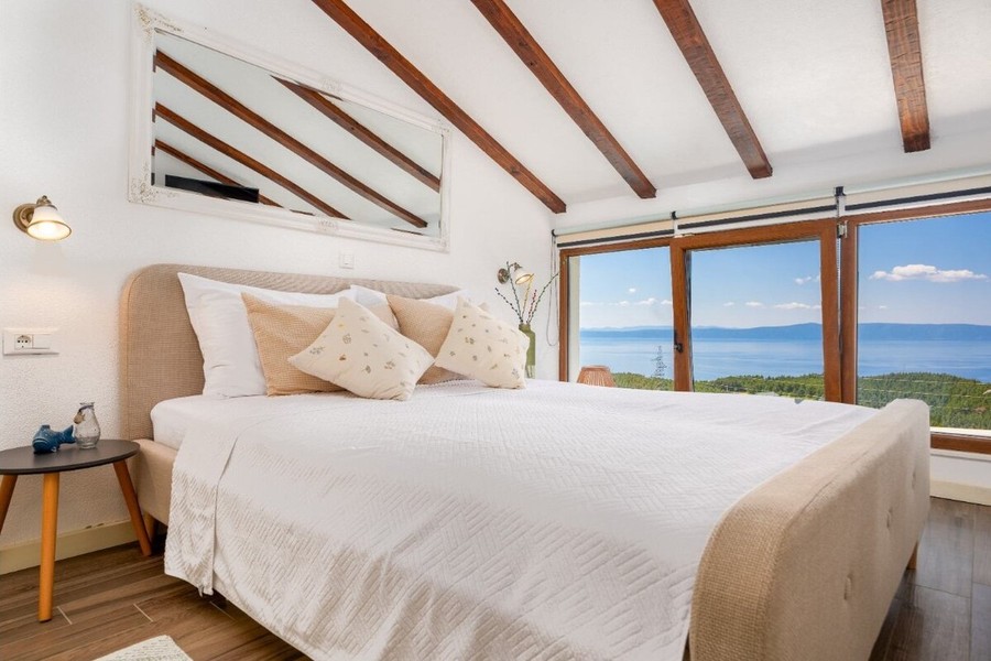 Schlafzimmer mit Holzbalken und Meerblick