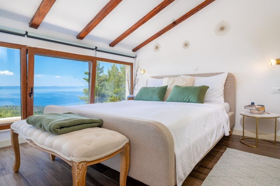 Schlafzimmer mit großer Fensterfront zum Meer