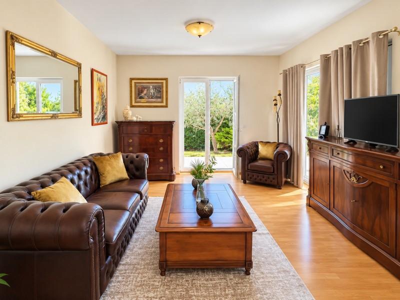 Wohnzimmer mit Ledersofa und Gartentür
