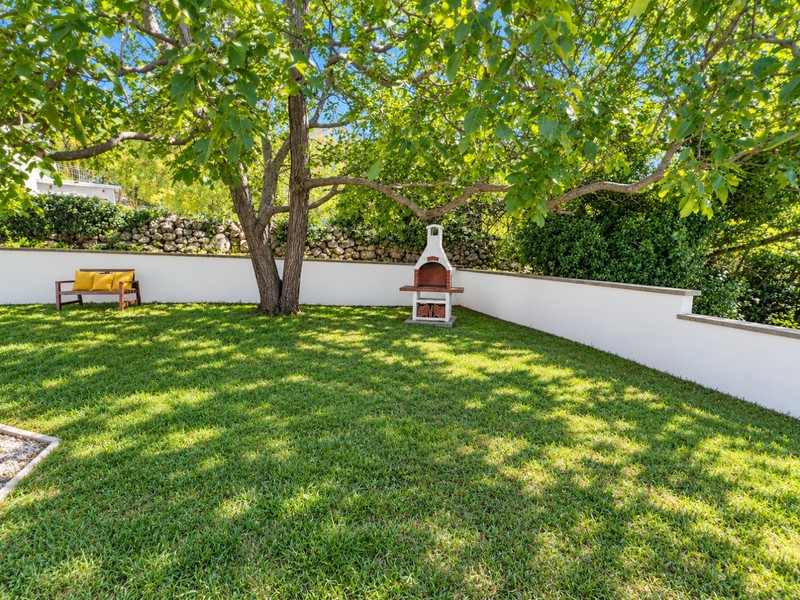 Garten mit Rasen, Baum und Grillplatz