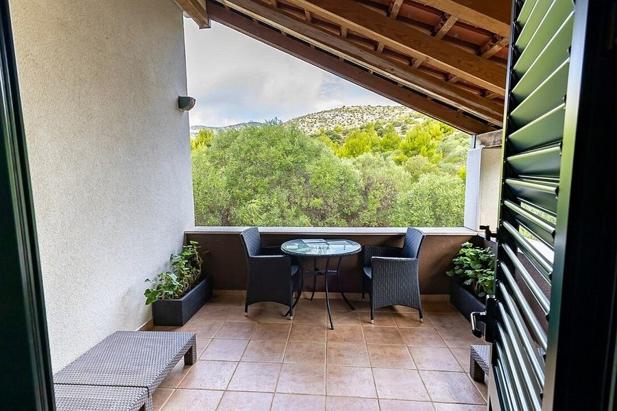 Überdachte Terrasse mit Holzdecke und Gartenmöbeln