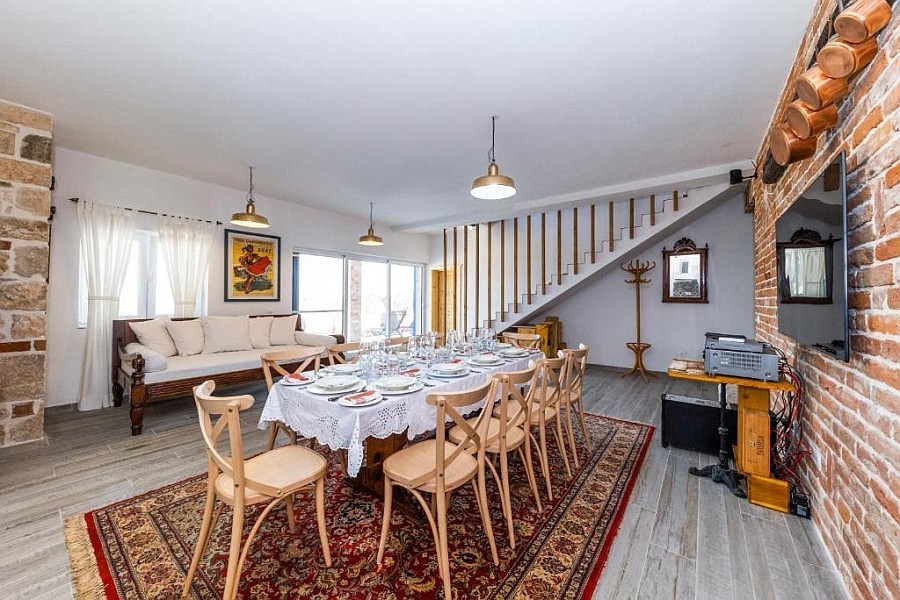 Wohnzimmer mit Esstisch und Treppe ins Obergeschoss