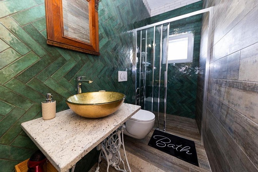 Badezimmer mit Dusche und grünen Fliesen