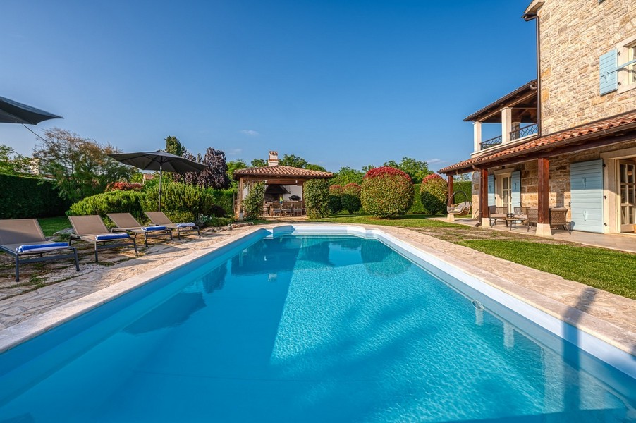Poolseite mit Liegen und Pavillon im Hintergrund