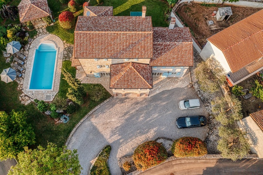 Haus mit Ziegeldach, Pool und Parkplatz von oben