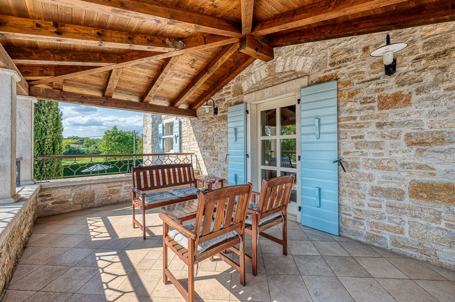 Terrasse mit Holzmöbeln und Blick ins Grüne