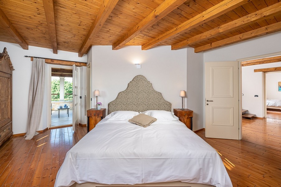 Schlafzimmer mit gepolstertem Kopfteil und Holzboden