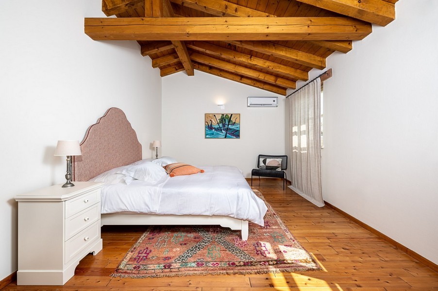 Schlafzimmer mit Kommode, Teppich und Gemälde