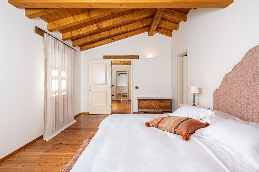 Schlafzimmer mit Vorhang und Holztruhe