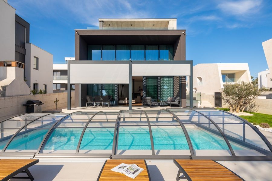 Villa mit Poolüberdachung und Sonnenliegen