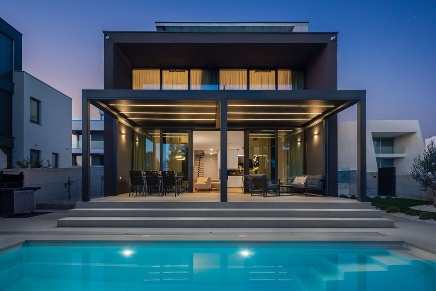 Villa am Abend mit beleuchtetem Pool