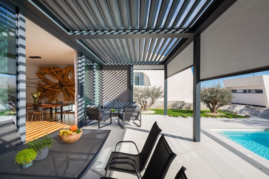 Überdachte Terrasse mit Esstisch am Pool