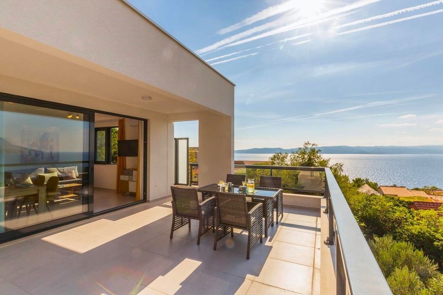 Terrasse mit Esstisch und Blick auf das Meer