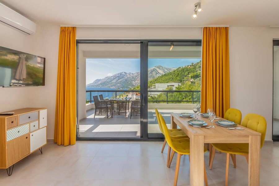 Essbereich mit gelben Stühlen und Meerblick