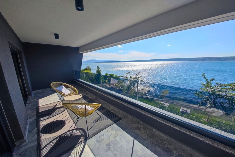 Loggia mit Sesseln und Blick auf das Meer
