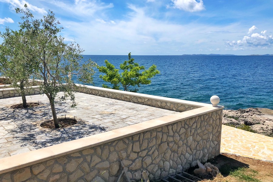 Steinterrasse mit Olivenbäumen am Meer