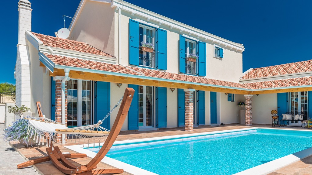 Villa mit blauen Fensterläden und Pool