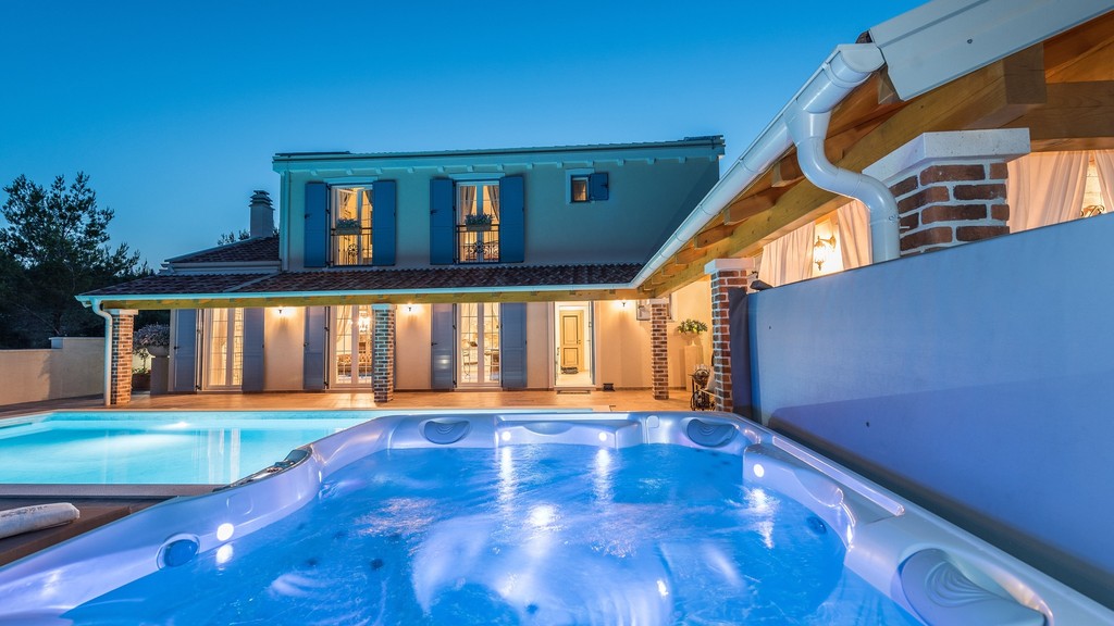 Beleuchteter Pool und Whirlpool am Abend