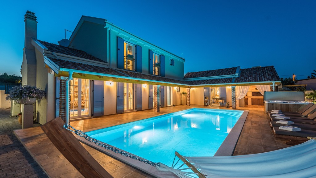 Villa am Abend mit Pool und Hängematte