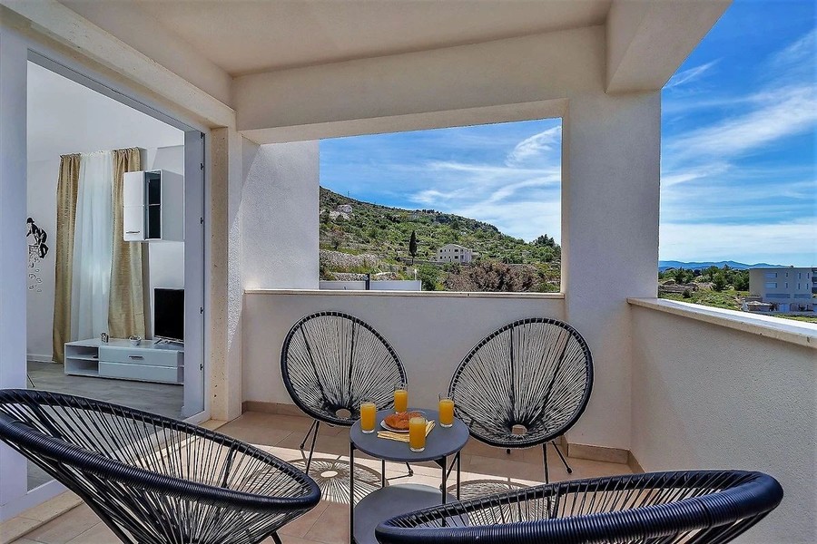 Terrasse mit Korbsesseln und Blick auf die Küste