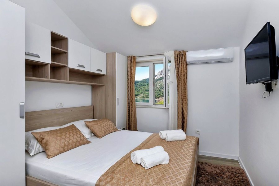 Schlafzimmer mit Doppelbett und Fernseher