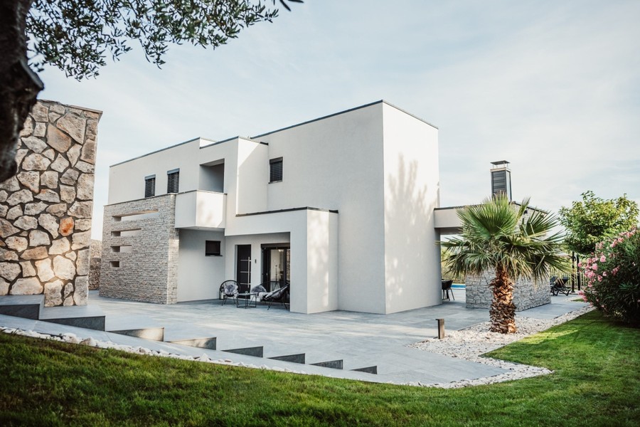Moderne Villa mit Rasen und Steinfassade
