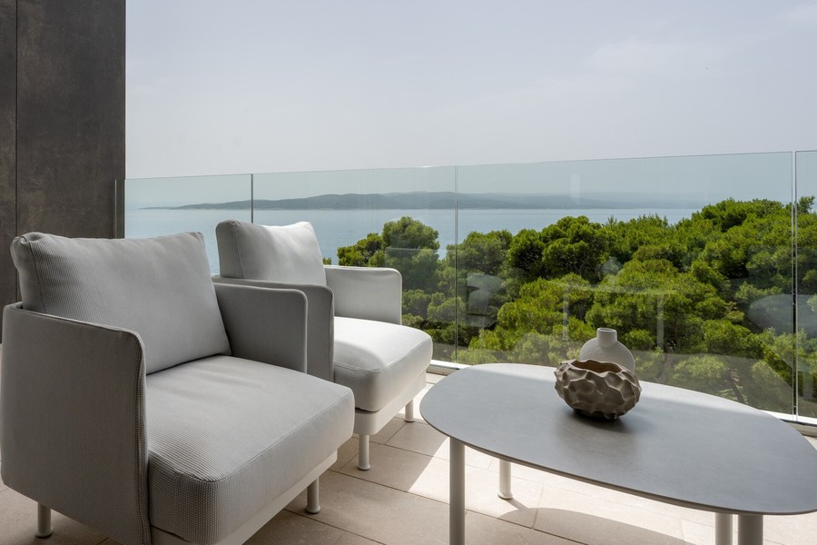 Terrasse mit Sesseln und Blick auf das Meer