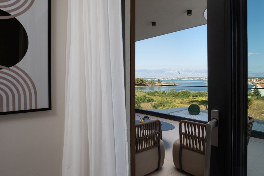 Terrasse mit Sesseln und Blick auf das Meer