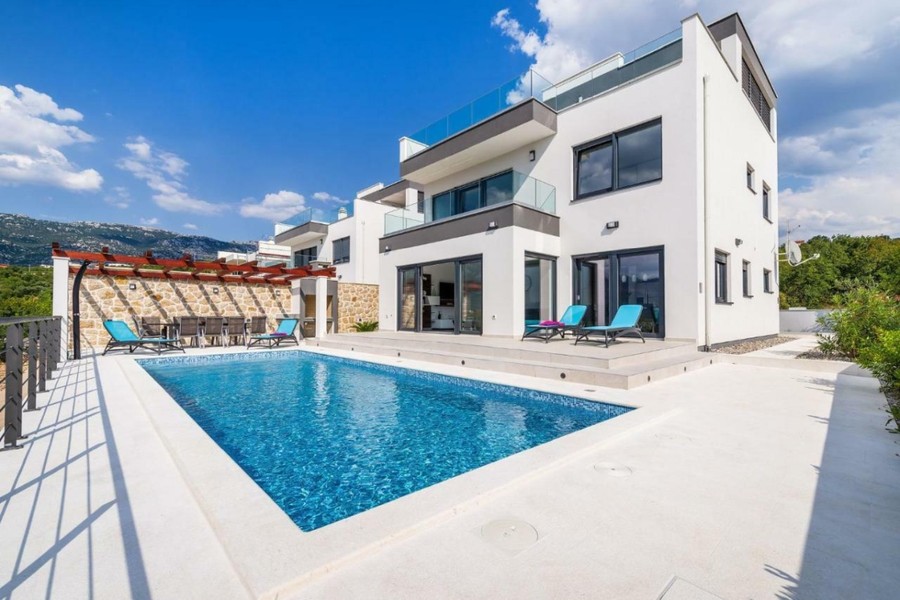 Weiße Villa mit Pool und Sonnenliegen