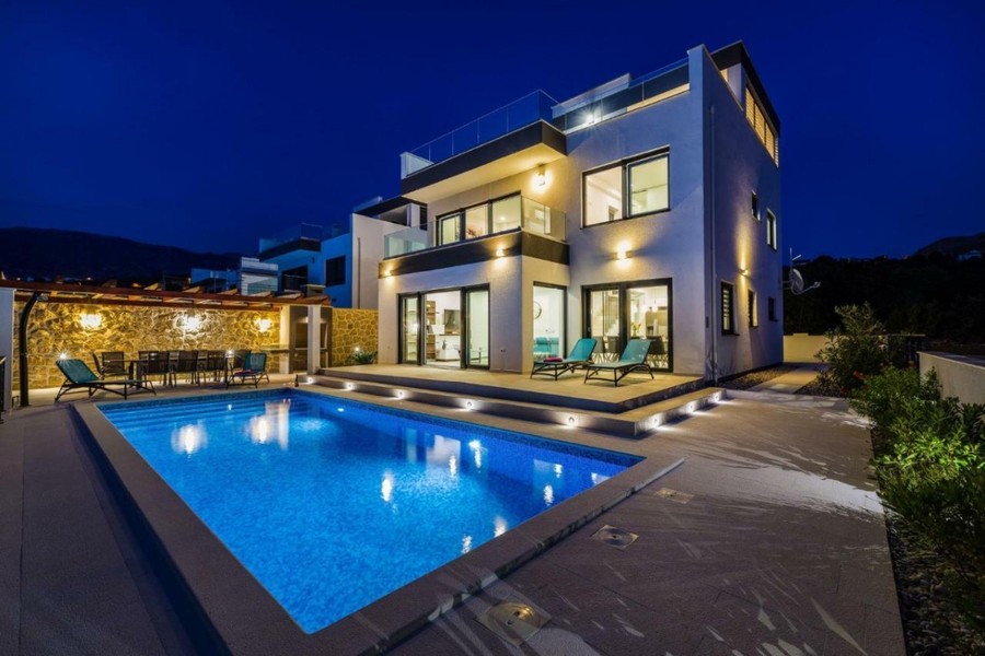 Villa am Abend mit beleuchtetem Pool