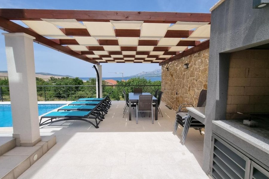 Terrasse mit Grill und Blick auf den Pool