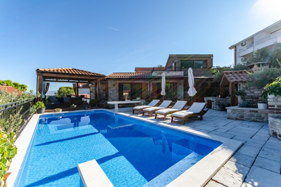 Pool mit Sonnenliegen und Pavillon