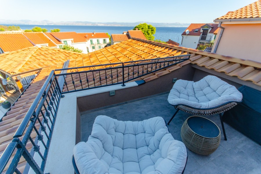 Terrasse mit Sesseln und Blick auf das Meer